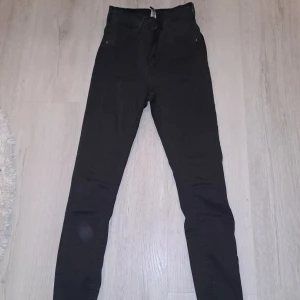 Svarta jeans från 77thFlea - Säljer ett par svarta jeans från 77thFlea i storlek L. De är tighta och har en hög midja, perfekt för både vardag och fest. Jeansen är i bra skick och har en klassisk design med fickor både fram och bak. Passar perfekt till en snygg topp eller en avslappnad hoodie. Byxan är inte fläckig de är pga kameran annars är dom super fina o sköna!✨️ säljer pga att dom är i fel storlek