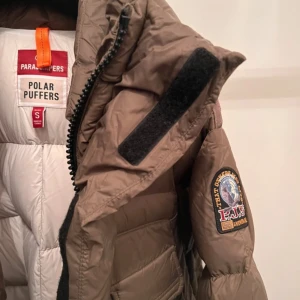 Grön/Khaki pufferjacka från Parajumpers - Säljer en Grön/Khaki pufferjacka från Parajumpers i storlek S. Jackan är perfekt för kalla vinterdagar med sin tjocka vaddering och långa ärmar. Den har en dragkedja framtill och flera praktiska fickor. Märket är känt för sin kvalitet och hållbarhet. Perfekt för dig som vill hålla dig varm och stilren i vinter!