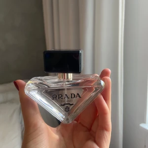 Prada Paradoxe Virtual Flower Eau de Parfum - Säljer en lyxig Prada Paradoxe Virtual Flower Eau de Parfum. Flaskan är elegant och triangulär med en svart kork, och kommer i en söt rosa förpackning. Perfekt för den som älskar exklusiva dofter och vill ha något unikt i sin samling. Flaskan är på 50 ml och är påfyllningsbar. Passa på att köpa denna fantastiska doft! HELT OANVÄND, säljer pgr av har en till likadan 