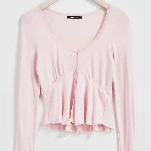 Rosa långärmad topp från Gina tricot  - Säljer en söt rosa långärmad topp från Gina Tricot. Den har en v-ringad design med en liten rosett framtill och volangdetaljer vid nederkanten. Perfekt för vår och sommar! 🌸
