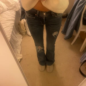 Blåa jeans från gina  - Ett par skit snygga jeans från gina som jag klippt egna hål i! 🤩Jag är 165 cm och de passar perfekt på mig. Det är 2 hål på framsidan och två små på bakfickorna men de är bara på fickorna alltså inte på innersta lagret av jeansen! Midjemått 36 cm , innerbenslängd 80cm , grenhöjd 20 cm💕 Hör av er om ni har frågor!