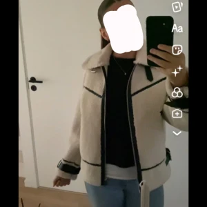 Beige teddyjacka med svarta detaljer - Säljer en supermysig beige teddyjacka med svarta detaljer. Den har en dragkedja framtill och långa ärmar. Perfekt för höst och vinter när du vill hålla dig varm och stilren. Jackan är i mycket bra skick och passar perfekt till både vardag och fest. Helt ny utan pris lapp (från beshka) Säljer pga kommer ej till andvändning.