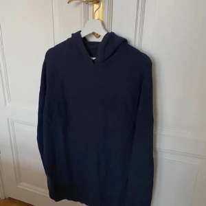 Mörkblå hoodie - Säljer en stilren stickad mörkblå hoodie, som passar till det mesta. Skriv i dm vid några funderingar.