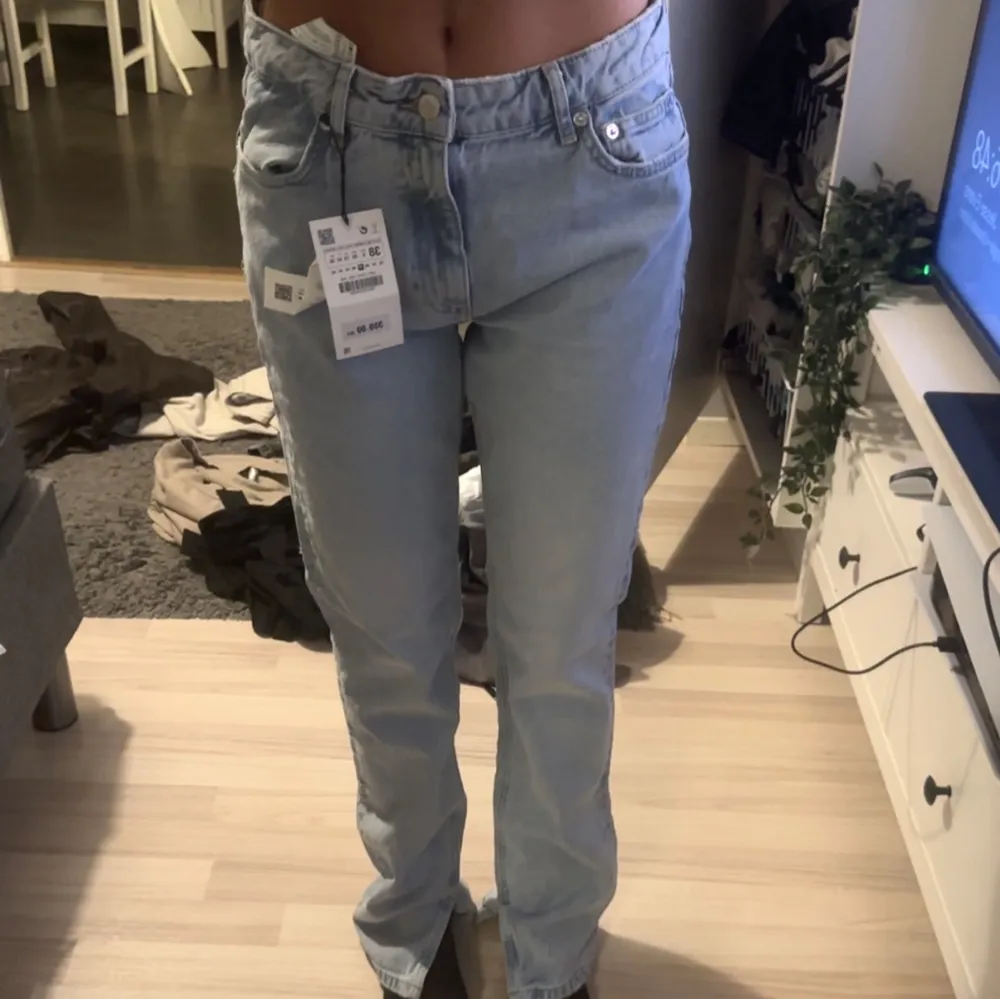 Ljusblå straight jeans från zara med slits längst ner. Aldrig använda därav lapparna kvar.💙💙. Jeans & Byxor.