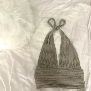 Halterneck topp - Snygg beige halterneck topp med knytning i nacken. Perfekt för fester eller utekvällar.Grå beige i färgen🩷Moa Matsson kollektion med nakd.