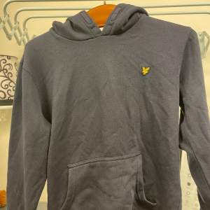 Säljer en snygg mörkblå hoodie från Lyle and scott i storlek 14/15 y(passar även lite mindre än S) Perfekt för höst och vinter med sin huva och praktiska ficka framtill. Passar både till alla tillfällen. Hör av dig vid intresse!