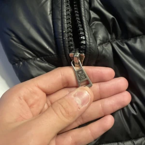 Svart pufferjacka från Moncler  - Säljer en snygg svart pufferjacka från Moncler. Jackan har en dragkedja framtill och ett broderat Moncler- vid armen . Perfekt för kyliga dagar med sin quiltade design. Köpt från vongrevn för 7000kr kan gå ner lite 100 lappar 