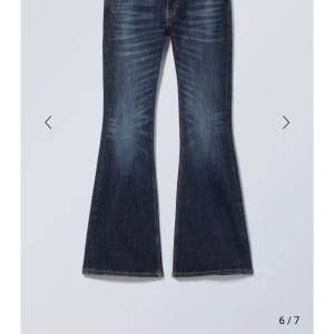 Blå Low waist bootcut jeans - Snygga mörkblåa lowwaist bootcut jeans från Weekday, modellen ”Flame Low waist”. Nästan helt oanvända 