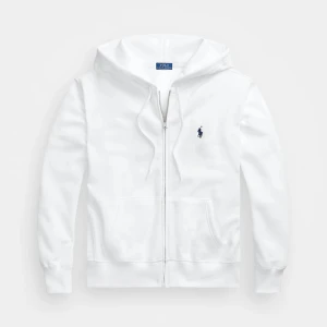 Vit hoodie från Ralph Lauren - Nypris 2075 kr.                                                      Säljer en stilren vit hoodie från Ralph Lauren med dragkedja och det klassiska logotypbroderiet på bröstet. Tröjan har en bekväm passform med långa ärmar och en praktisk huva. Perfekt för en avslappnad look.