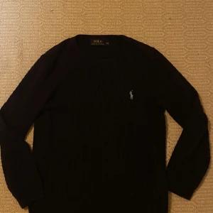Marinblå stickad tröja från Polo Ralph Lauren - Säljer en stilren marinblå stickad tröja från Ralph Lauren. Säljer då jag har växt ur tröjan och vill göra mig av med den. Storleksmässigt passar den mellan 160-165 men går att använda om man är längre.