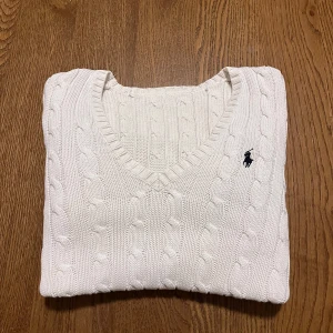 Vit stickad tröja från Ralph Lauren - Vit Ralph Lauren kabelstickad dam, svart ponnylogga.  🌟Riktigt fint skick, endast använd ett par gånger. Det enda negativa är lappen som är avskuret.  🐑100% bomull, riktigt bekvämt och stretchigt material.  📬Jag skickar inom samma eller nästa dag efter köpet.   📏Storlek S, men passar XS till. Mått nedan  📐42cm axelbredd, 60cm full längd, 49cm ärmlängd (alla mätt på plan mark)  😊 Ställ gärna frågor. 