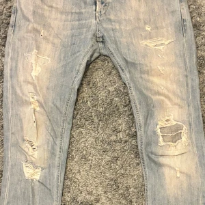 Dondup george - Säljer ett par ljusa jeans från  Dondup George med slitna detaljer på framsidan. Storlek 31, skick 8/10 knappt använda, köpte nya för 2700kr
