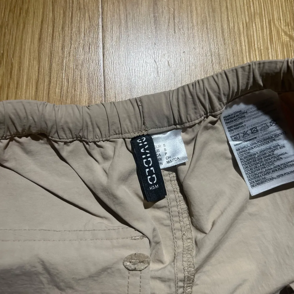 Säljer ett par beige cargobyxor från H&M. Byxorna har en loose passform med elastisk midja och snörning. Perfekta för en avslappnad stil med praktiska fickor på sidorna.🌟🤍Har använd de max 1-3 gånger☀️. Farkut & Housut.