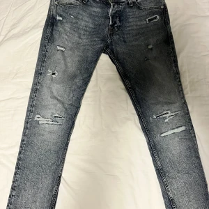 Grå jeans med slitningar Jack and Jones slim Glenn - Snygga grå jeans med coola slitningar för en trendig look. De har en klassisk femficksdesign och en bekväm passform. Inte använda ny pris 799kr mitt pris 400kr