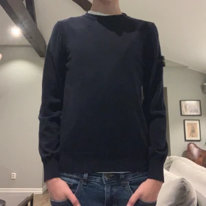 Svart tröja från Stone Island Junior - Säljer en stilren mörkblå tröja från Stone Island Junior. Tröjan har långa ärmar och en ikonisk logga på ärmen. Perfekt för en avslappnad och trendig look. Hör av er vid frågor och funderingar!skick 9/10
