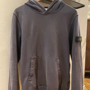 STONE ISLAND HOODIE - SÄLJER NU MIN STONE ISLAND HOODIE DÅ DEN ÄR FÖR LITEN. DEN ÄR SÅKLART ÄKTA OCH ANVÄND I UNGEFÄR 10 MÅNADER. INGA STORA BEKYMER MED TJÖJAN. ENDAST ETT TVÅ SMÅ HÅL SOM MAN KNAPPT SER ( SE BILD 2). DEN PASSAR EN 14 ÅRING (170-175 CM) SÅ SKULLE UPPSKATA ATT DEN ÄR SOM EN STORLEK S I HERR. KÖPT FÖR UNGEFÄR 1500 PÅ NK.                                                                 KAN GÅ NER I PRIS VID SNABB AFFÄR.                SKRIV OM NI HAR NÅGRA FRÅGOR