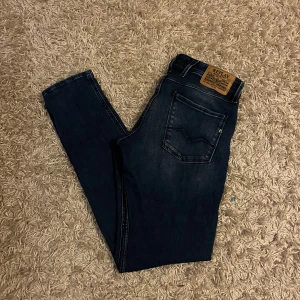 Mörkblå slim  jeans från Replay Anbass - Snygga mörkblå jeans från Replay, modell Anbass. De har en klassisk femficksdesign. Perfekta för en stilren look. Riktigt stretchiga och väldigt mjuka. Mycket bra skick, strlk 33/34. Fraktas antigen samma dag som köp eller dagen därpå🙌❌