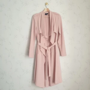 Rosa tunn trenchcoat  - 🎀FÖRST TILL KVARN!🎀 En tunnare trenchcoat i fin rosa färg med fina resinknappar. Kappan är från märket objekt i creppad material. Har strukturerade axlarna med vattenfall krage. En fin harmoni i former som gör att ens look ser clean ut men flowy på samma gång