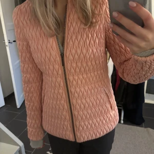 Rosa quiltad jacka från Vero Moda - Säljer en snygg rosa quiltad jacka från Vero Moda. Jackan har en dragkedja framtill och långa ärmar. Perfekt för att hålla stilen när det är lite kyligare ute. 🧥✨
