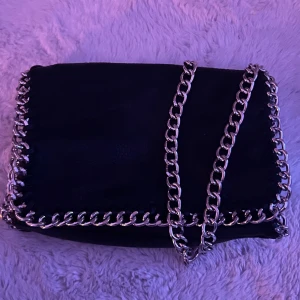 Svart axelväska från Tiamo  - Säljer denna super snygga och trendiga axelväska från Tiamo!! Den är 27 x 17 cm och passar alla!! Säljer då den inte längre kommer till användning. Använt 1-2 gånger och är i super bra skick!! Skriv innan köp och om ni har frågor :) köparen står för frakt!! 💕 