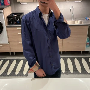 Burberry skjorta - Tja säljer nu en riktigt snygg burberry skjorta i fint skick. Riktig stiligt skjorta och passar perfekt till ett par sköna jeans! Storlek M i grunden men sitter mer som en S. Personen på bilden är 177cm! Skjortan är självklart äkta 🙏. Bara att fråga vid eventuella funderingar mvh 