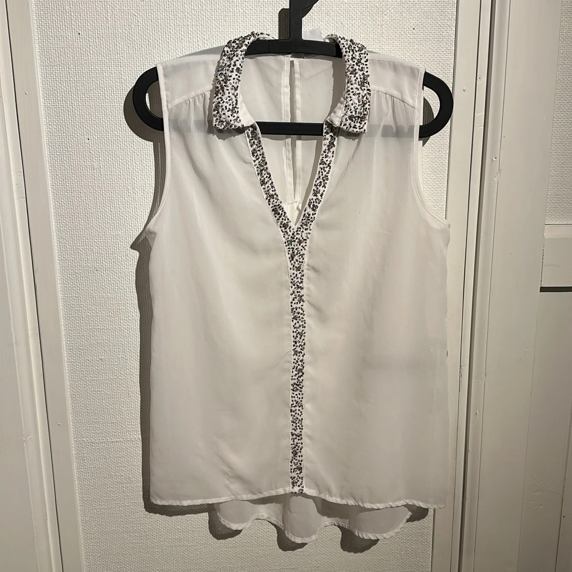 Vit ärmlös blus med pärldetaljer