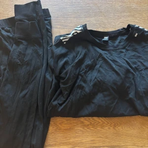 Svart underställ från Helly Hansen - Säljer ett svart underställ från Helly Hansen. Tröjan har långa ärmar och byxorna är i en matchande stil. Perfekt för kalla dagar eller som baslager vid utomhusaktiviteter. Klassisk design med diskreta detaljer på axlarna. Änvänd ca 2-3 gånger. 