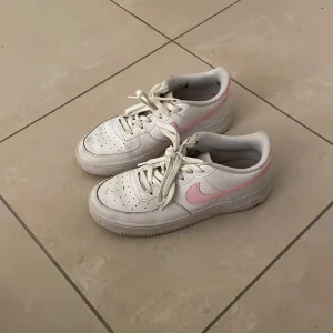 Nike sneakers i vitt och rosa - Säljer ett par Nike air forces i vitt och rosa. Har blivit använda och Förekommer lite defekter i ena skon. Skorna är i storlek 39. Jag kan ej frakta via instanbox.
