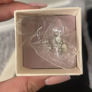 Silverörhängen med pärlor från Lily and Rose - Eleganta silverörhängen från Lily and Rose, dekorerade med vackra pärlor och gnistrande stenar. Perfekta för att ge en touch av glamour till din look. Helt oandvända fick de i födelsedagspresent 