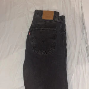 Svarta Levi’s Jeans  - Snygga svarta levi’s jeansbyxor i modellen Middy Straight. De har en klassisk femficksdesign och en rak passform som ger en tidlös look. Perfekta för en stilren vardagsoutfit. 