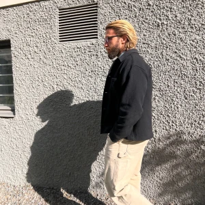 Svart overshirt från arket - Snygg svart overshirt från arket, perfekt för lager-på-lager-stilen. Den har en klassisk design med långa ärmar och en stilren look. Passar bra över en jeansskjorta för en avslappnad men trendig stil.