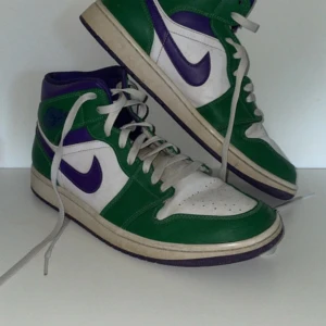 Nike Air Jordans hulk - Snygga Nike Air Jordans med en fräsch färgkombination av grönt, lila och vitt. Skorna har klassisk snörning och en hög design som ger bra stöd. Perfekta för dig som vill sticka ut med stil.