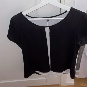 Blus - En blus med öppen i fram och liknande i bak. Skulle säga att den passar som en S