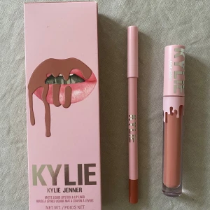 Kylie Jenner Matte Liquid Lipstick & Lip Liner - Candy K - Kylie By Kylie Jenner lip kit i fargen Candy K 802. Kitet innehäller Matte Liquid Lipstick och läppenna Lip Liner som är känd för att sitta väldigt bra. Läppstiftet är öppnat för att se färgen och pennan är målad med 2 gånger för att se färgen ordentligt. Nypris är 455.