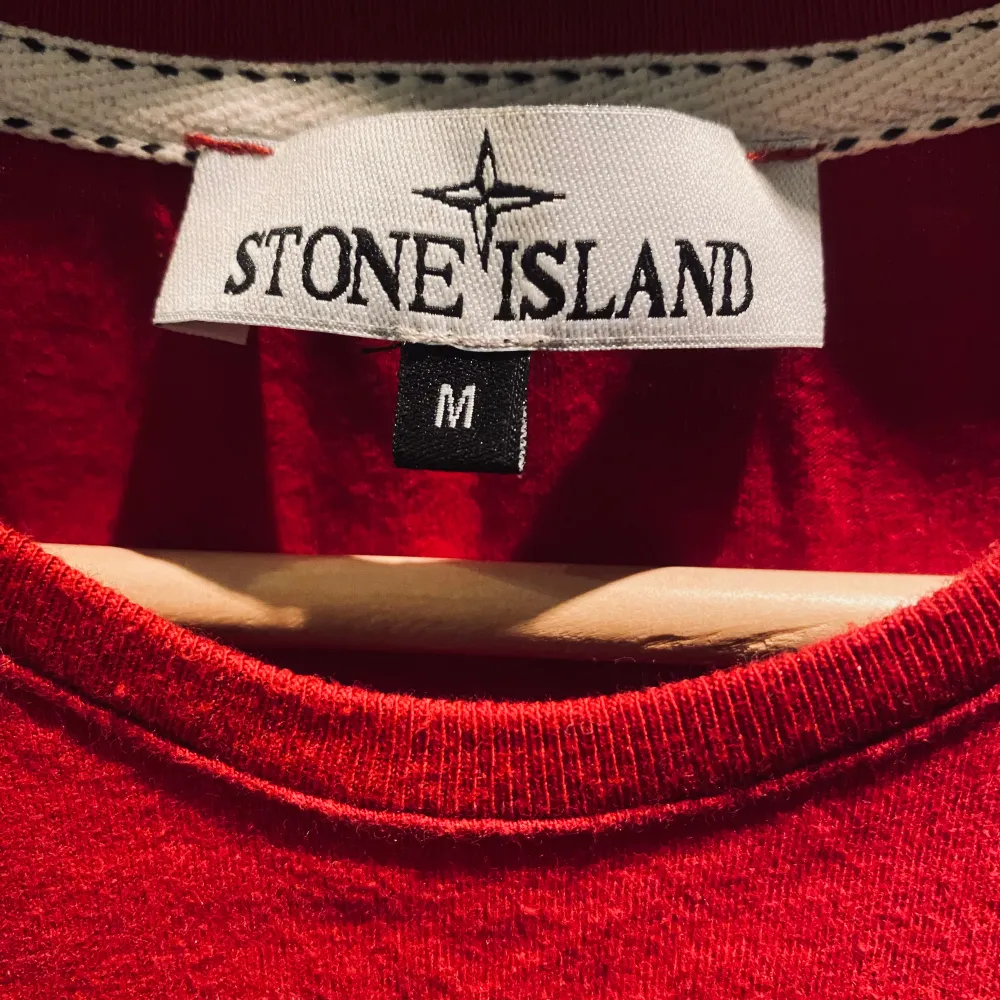 Säljer en röd t-shirt från Stone Island i storlek M. Den har en Stone Island logga på framsidan och är gjord i mjukt bomullsmaterial. Perfekt för ett flertal olika tillfällen. T-shirten är kortärmad och i bra skick. loggan på vänstra axeln är dock saknad, därför tillkommer priset.. T-shirts.