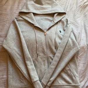 Ralph Lauren zip hoodie | Storlek M | Grå - Ralph Lauren zip hoodie | Storlek S | Grå | Ägd sedan april 2024 | Använd en del | Lite små märken på snörena men inget synligt | Kontakta vid funderingar✅