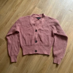 Rosa stickad kofta från XOXO Friends - Gullig rosa stickad kofta från XOXO Friends. Den har en croppad passform och ribbade muddar vid ärmslut och nederkant. I storlek 158/164 men passar absolut xs! Få täcken på användning som lite nopprig men inget märkvärdigt! Perfekt till hösten! 