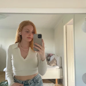 Ribbad v-ringad topp - Vit topp i ribbat material med v-ringning och krage. Mycket bra skick! 