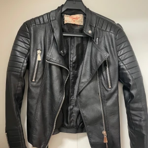 Skinnjacka  - Skinnjacka i storlek 38 i använt skick och lite sliten upptill. Pris 120kr.