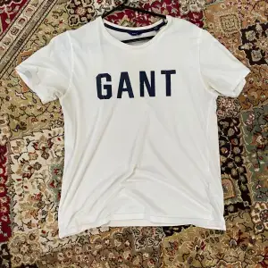 En vit gant t-shirt som är i helt ok skick. Bokstäverna är lite slitna men annars är den bra. Skriv för mer bilder eller info.