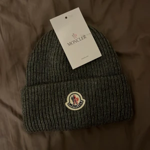 Moncler mössa - Tja säljer en snygg moncler mössa. Aldrig använd, topp skick. Perfekt nu till det kallare vädret. Pris går att diskutera 