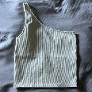 Ribbad one shoulder topp - Ribbad vit one shoulder topp från Gina Tricot i storlek S! Normal i storleken och bara använd mågra gånger!