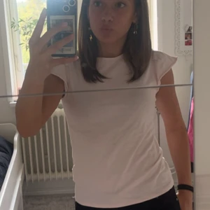 Rosa volang tröja - En rosa volang t-shirt. Använd fåtal gånger och har inga defekter, köpt från Mango för några år sedan och är i storlek 140 eller 11 år. 