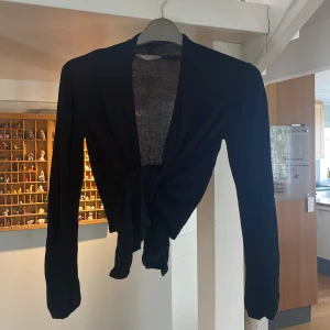 Svart kofta - Svart kofta, lite längre där fram som gör att man antingen kan knyta den eller ha den öppen, fin att ha till en fest topp under vintern:) Säljer för att den är för liten. 