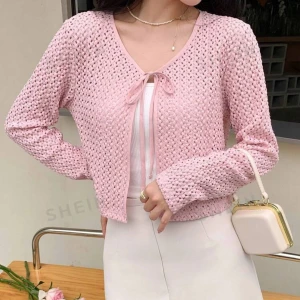 Rosa stickad kofta från Shein - Säljer en superfin rosa stickad kofta från. Den har en söt knytning framtill och är perfekt för vår och sommar. Koftan är croppad och har långa ärmar, vilket gör den både trendig och bekväm. Perfekt att ha över en topp eller klänning.