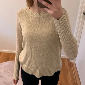 Beige stickad tröja - Säljer en supermysig beige stickad tröja. Den är perfekt för kyliga dagar med sin långa ärmar och ribbade kanter. Tröjan har en enkel och stilren design som passar till allt. Perfekt för både vardag och mysiga hemmakvällar!