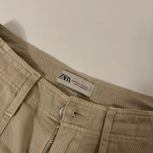 Cargio byxor - Ett par beiga cargio byxor i storlek 32