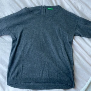 Grå tröja - Säljer denna gråa tröjan från untited colors of benetton! Lite kort i armarna och den har ett litet blixtlås där bak. Köpt secondhand men använd fåtal gånger!💕