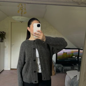 Stickad kofta - Stickad kofta i ullblandning med knappar 💓💓Lapparna är tyvärr bortklippta men skulle säga att storleken är typ en L, inte så oversize i modellen. Använd några fåtal gånger bara!