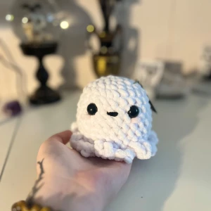 Vit stickad bläckfisk - En supergullig vit stickad spöke med stora svarta ögon. Perfekt som dekoration eller en mysig liten kompis. Den är handgjord och har en mjuk och fluffig textur.